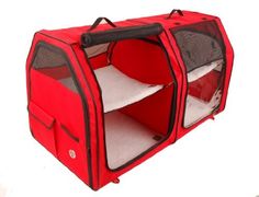 a red pet carrier with a bed inside