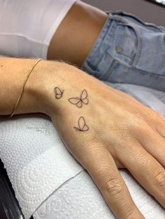 a person with a butterfly tattoo on their left hand