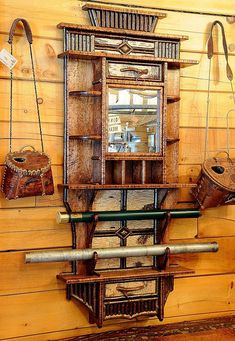 an old fashioned wooden shelf with mirrors and purses hanging from it's sides