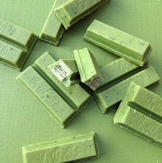 several pieces of green chocolate sitting on top of a table next to eachother