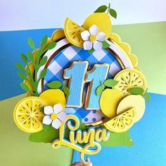 a cake topper with the number one decorated in lemons and blue gingham