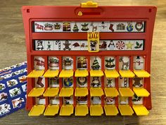 a red toy cash register sitting on top of a wooden table next to other toys