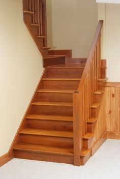 a set of stairs in a house with carpeted flooring and white rugs