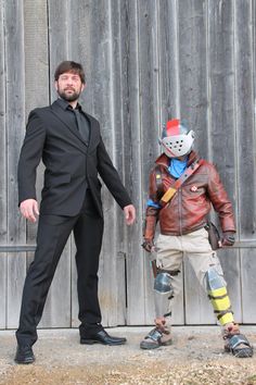 a man in a suit and tie standing next to another man wearing roller skates