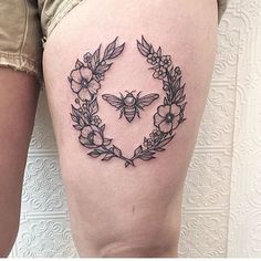 a woman's thigh with flowers and butterflies in the shape of a heart