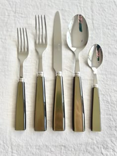 five forks, two spoons and one knife on a white cloth