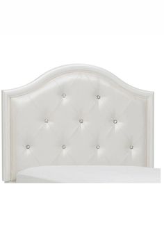 a white headboard with diamond buttons on the top and bottom panel, in front of a