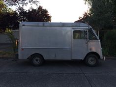 an ice cream truck is parked on the side of the road in front of some trees