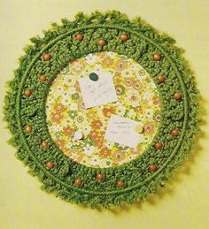 there is a green and yellow flowered doily with two tags in the center