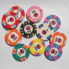 a pile of colorful poker chips sitting next to each other on top of a table