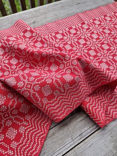 a red and white patterned fabric sitting on top of a wooden table