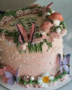 a pink cake decorated with butterflies and flowers