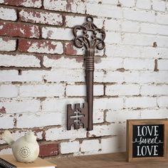 an old key is hanging on the wall next to a sign that says love sweet love