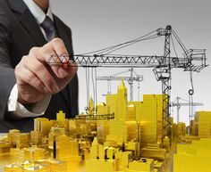 a man in a business suit writing on a piece of paper with construction drawings behind him