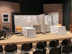 an empty stage with chairs and tables in front of it on display for people to see