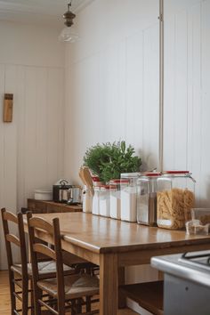 the kitchen table is covered with jars and utensils for cooking or baking ingredients