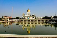 a large building sitting next to a body of water in front of a tall white building