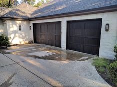 a house with two garage doors and no one in the driveway or front yard area