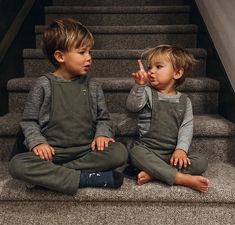 two little boys sitting on the stairs laughing