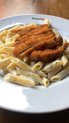 a white plate topped with pasta and meat