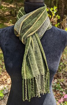 a woman wearing a green scarf on top of a mannequin