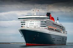 a large cruise ship in the water under a cloudy sky