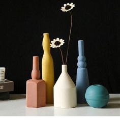 several vases with flowers in them sitting on a table