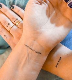 two women with matching tattoos on their arms, both holding each other's hands