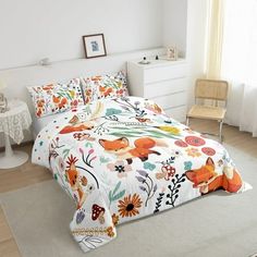 a bedroom with white walls and flooring has a floral comforter on the bed