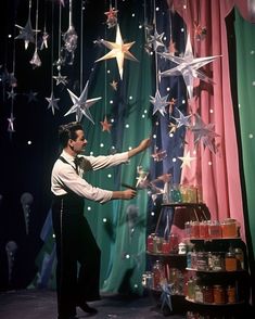 a man standing in front of a display of stars and confetti on a table