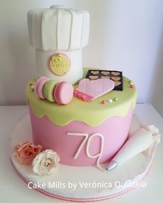 a cake that is sitting on top of a white table with pink and green frosting