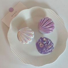 two seashells sitting on a paper plate with a tag attached to it's side