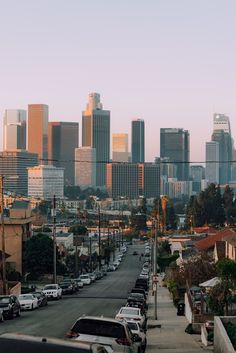 a city skyline is shown with cars parked on the street