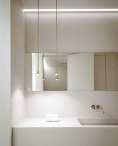 a bathroom with a sink, mirror and lights