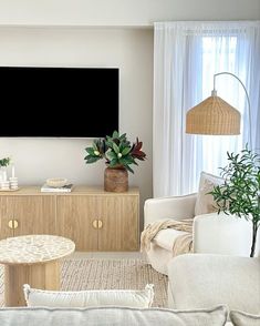 a living room filled with furniture and a flat screen tv mounted to the side of a wall