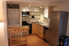 a small kitchen with stainless steel appliances and wood flooring is pictured in this image