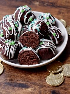 chocolate truffles with white frosting and sprinkles on a plate