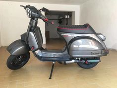 a motor scooter parked in a room with tile flooring and white walls