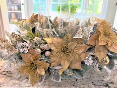 a vase filled with lots of flowers on top of a marble counter covered in snow