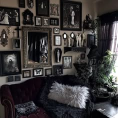 a living room filled with lots of framed pictures on the wall and a couch in front of it