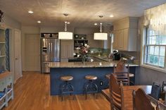 a kitchen with wooden floors and white walls