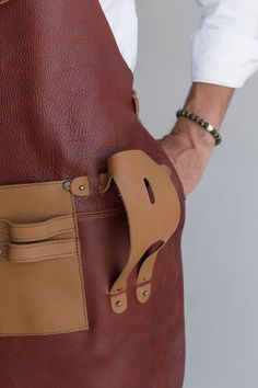 DESCRIPTION: Introducing our meticulously crafted leather aprons from OAK & ELK, designed with versatility and functionality in mind. Whether you're a grill master, a carpenter, a welder, or just someone who loves a good DIY project, our aprons are built to support your needs. FEATURES: Multiple Pockets & Tool Spaces: Our aprons come equipped with various pockets and dedicated spaces for all your grill tools, ensuring everything you need is within easy reach.Beverage Handle: Unique to our design, we’ve included a handle specifically for holding your beer or any other beverage, keeping you refreshed while you work.Premium Leather: Made from high-quality leather, these aprons are durable, stylish, and comfortable to wear for long hours.Adjustable Straps: Designed to fit all body types, our a Leather Aprons, Grill Tools, Pocket Tool, Leather Apron, Copper Brown, Grilling Tools, Grill Master, Long Hours, High Quality Leather