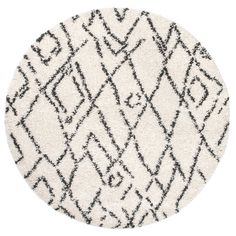 a round rug with black and white designs on the top, in front of a white background