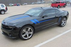 a black car with blue stripes parked in a parking lot