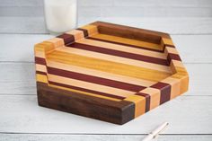 a wooden cutting board with two knives on it and a glass of milk next to it