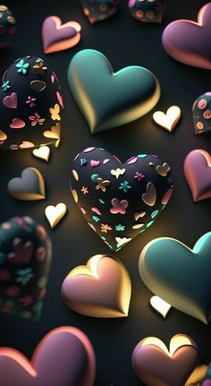 many heart shaped objects are scattered on a black surface, with pink and blue hearts in the middle