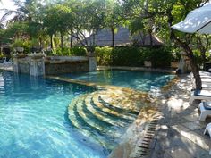 an outdoor swimming pool with steps leading up to it and trees in the back ground