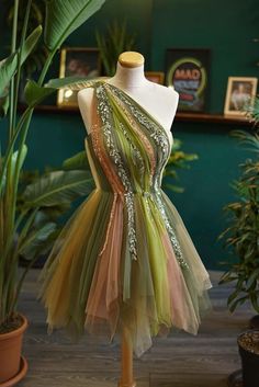 a dress on a mannequin in front of potted plants