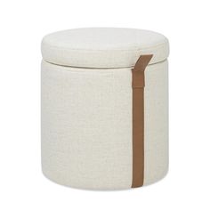 a round storage box with brown leather straps