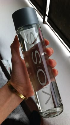 a woman is holding a water bottle with the word yoso written in white on it